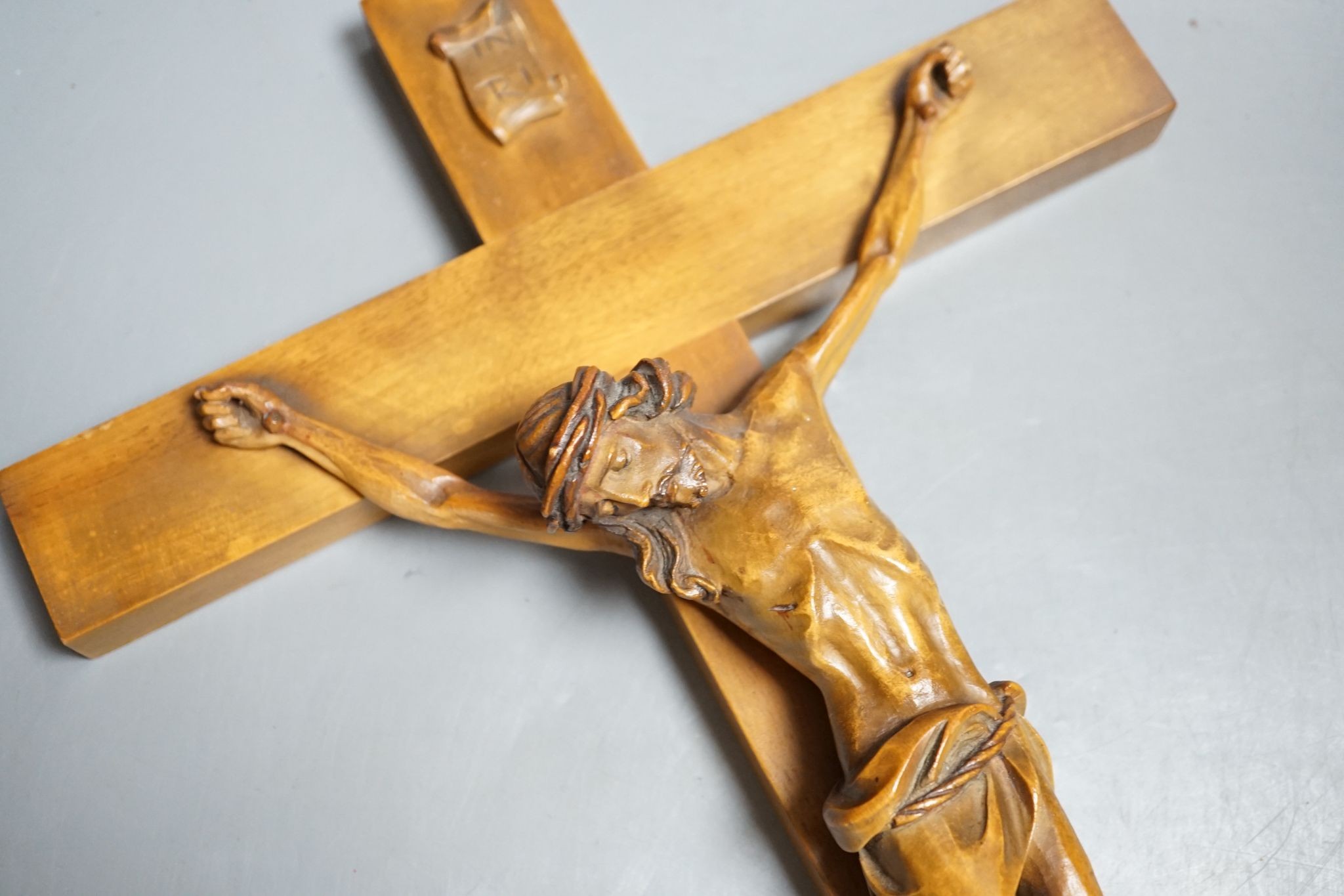 A carved crucifix and a framed metal Peruvian colonial crucifix, 50cm